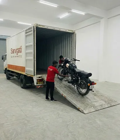 Motorcycle being carefully loaded onto a transport carrier