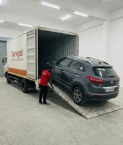 Car being loaded onto a closed container carrier