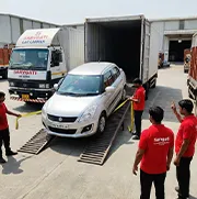 Car with RJ number plate being loaded into closed container carrier by trained staff