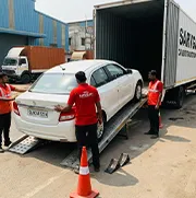 Car with Delhi registration number plate being loaded into closed container truck by Sarvgati team