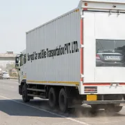 Closed container truck of Sarvgati transporting car with Delhi number plate on Indian highway
