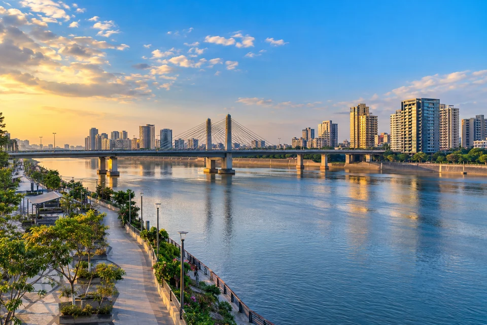 Illustration: Illustrative city view of Tapi River waterfront with Surat bridges and city buildings