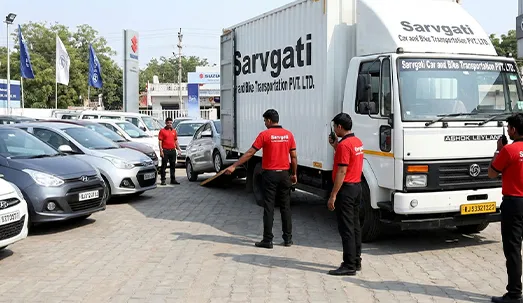 Multiple cars being loaded into closed container carrier in Jaipur for dealership transport
