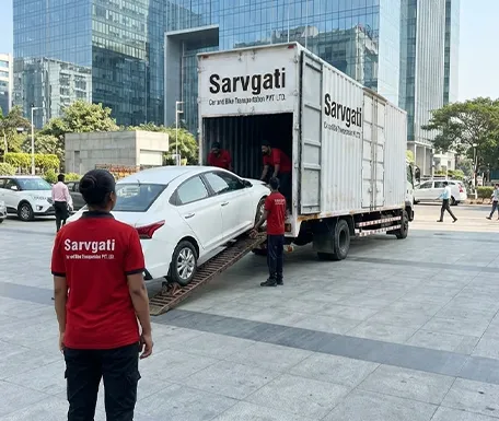 Car being loaded onto a closed container carrier by Sarvgati team